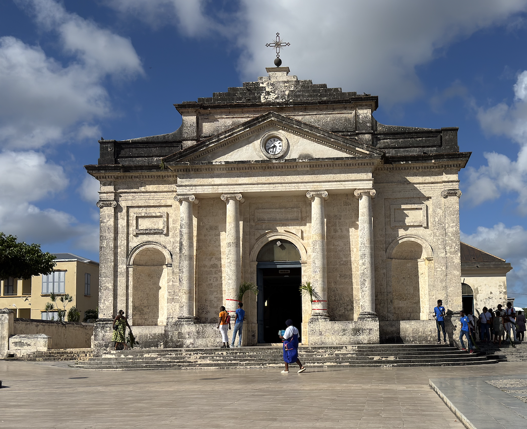 Église de Le Moule sur sa place, façade à colonnes sous un ciel bleu